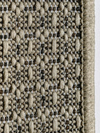 Primer plano del entramado tejido de alfombra de sisal color marfil.
