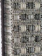 Detalle lateral de alfombra Sisalo Trilenium gris mostrando textura y acabado.