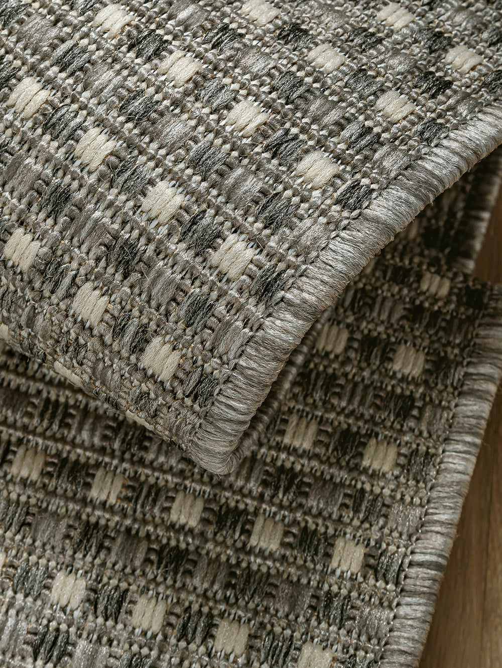 Acercamiento a la trama tejida de alfombra Sisalo Trilenium color gris.
