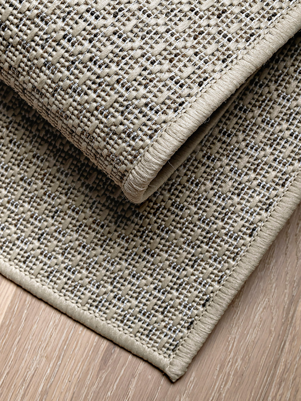 Detalle de dos capas de alfombra de sisal marfil mostrando espesor y terminación.