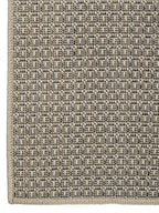 Detalle de la trama tejida de alfombra de sisal color marfil.