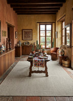Alfombra de sisal marfil en living cálido con detalles de madera natural.