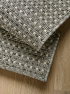 Detalle de alfombra Sisalo Trilenium gris con borde doblado para mostrar espesor.