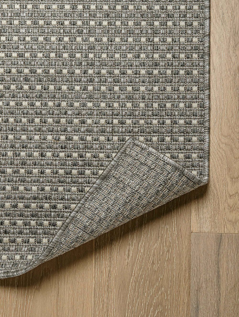 Esquina de alfombra Sisalo Trilenium gris mostrando textura y terminación.
